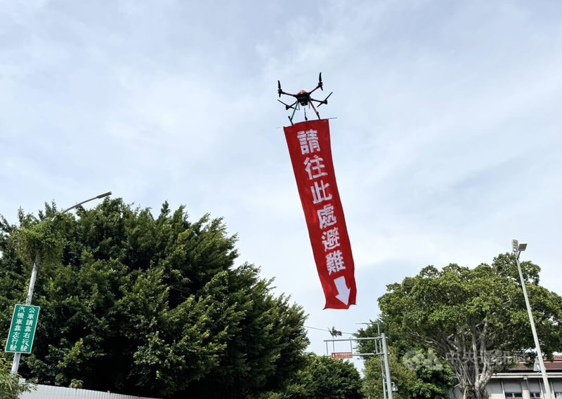 2026城鎮韌性（防空）演習13日下午在北部7縣市登場，因應演習期間行動網路降速，新竹市警方運用無人機吊掛防空避難指示布條，引導民眾迅速前往避難場所。中央社記者魯鋼駿攝　115年8月13日