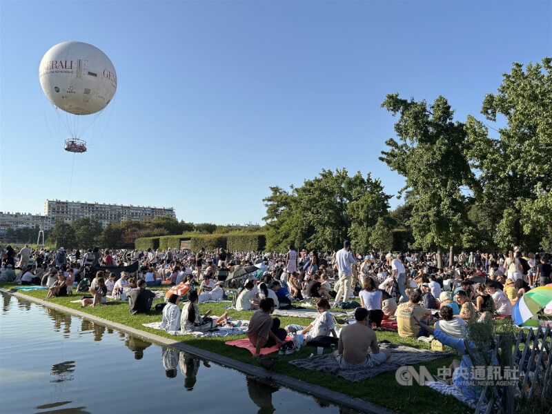 許多巴黎人12日晚間聚集在安德瑞・雪鐵龍公園觀賞日偏食。人們在草地上鋪墊子，一邊野餐，一邊等待食甚。中央社記者曾依璇巴黎攝　115年8月13日