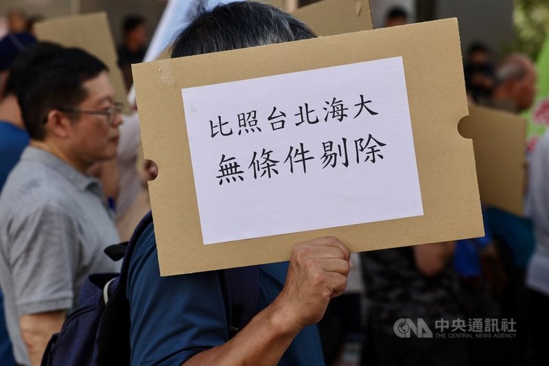 內政部17日召開社子島土地徵收審議小組專案會議，社子島自救會等團體到場表達訴求，民眾手持「比照台北海大 無條件剔除」標語，要求將既有聚落剔除區段徵收範圍。中央社記者王飛華攝　115年8月17日