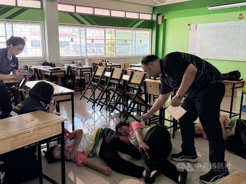 泰國曼谷一間中學18日舉行校園槍擊演練,學生模擬遭槍擊受傷,由老師及其他學生協助救援。中央社記者李宗憲曼谷攝 115年8月18日