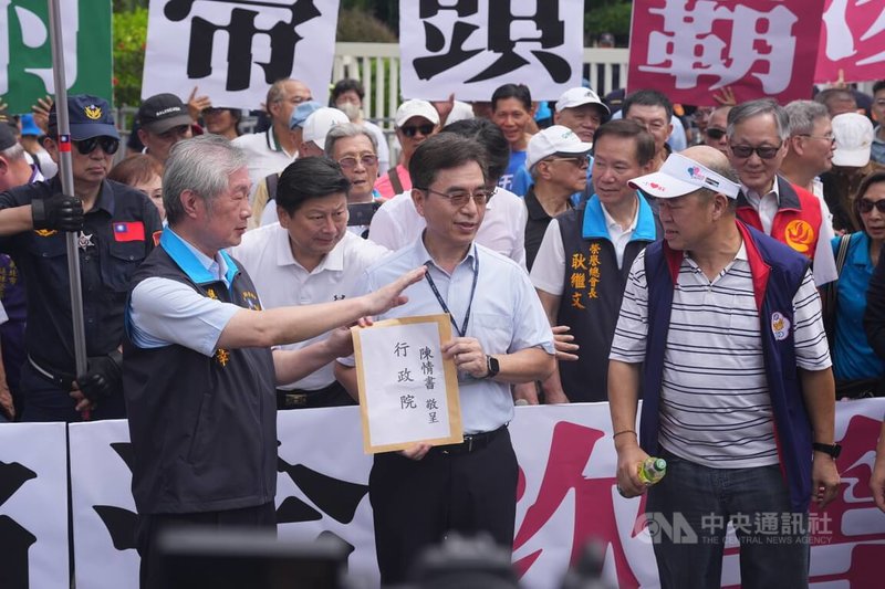 立法院民國114年三讀修正「軍人待遇條例」、「警察人員人事條例」，行政院卻暫緩編列相關預算，並聲請釋憲。退休警消20日前往行政院抗議，要求政府補足相關待遇與保障，政院派代表（中）接下陳情書。中央社記者徐肇昌攝　115年8月20日