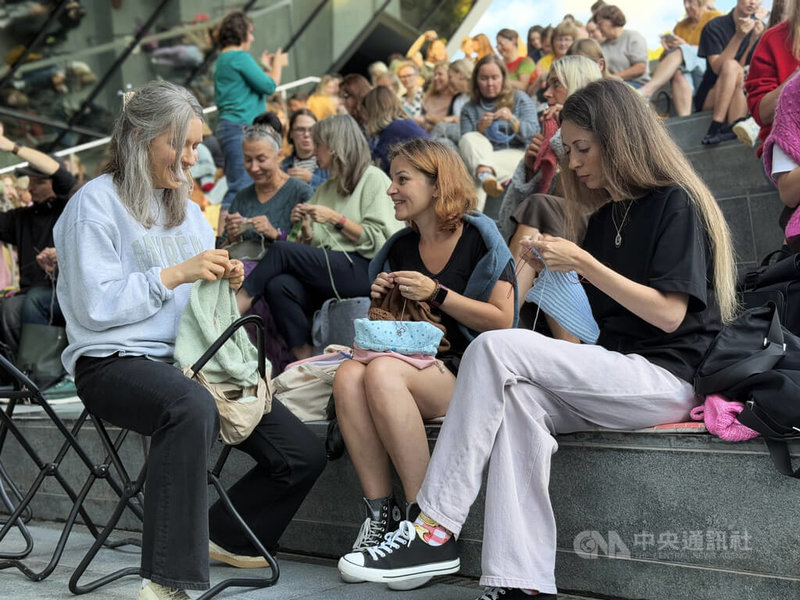 立陶宛博物館辦戶外編織節，現場可見不同年齡層的參與者圍坐在一起，手中拿著毛線與針具，一邊編織、一邊聊天交流。中央社記者游堯茹維爾紐斯攝　115年8月21日