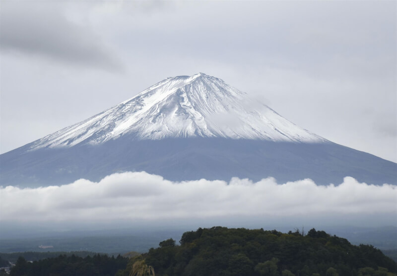 有日本男子20日與家人共爬富士山 （圖），途中體力不支7歲小兒子獨留在高海拔的山路上，引發爭議。（共同社）