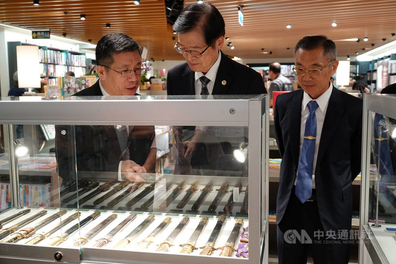 退輔會主委嚴德發（中）22日出席「軍人魂」新書發表會，由作者、退輔會就醫保健處長劉峻正（左）導覽現場所展出佩劍。中央社記者吳書緯攝　115年8月22日