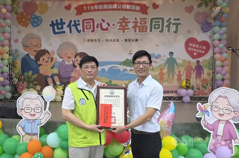 澎湖縣副縣長林皆興（左）22日在祖父母節活動中，表揚積極推展家庭教育績優的馬公市中興國民小學，由校長鄭文健（右）代表領獎。中央社 115年8月22日
