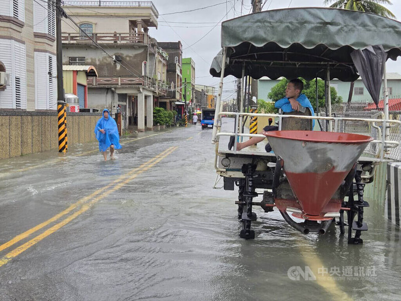 大雨不斷，屏東縣崁頂鄉港東村24日淹水，數名居民上午即出動各式機具，協助運送物資，並待命投入救災。中央社記者黃郁菁攝　115年8月24日