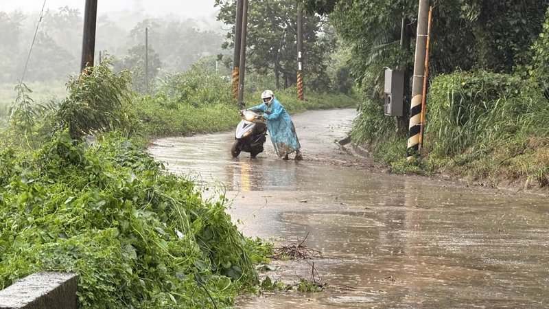 台東縱谷地區23日入夜後雨勢未歇，多處積水，有騎機車巡視農田的民眾不慎滑到，只好牽起機車緩步前行。（民眾提供）中央社記者李先鳳傳真　115年8月24日
