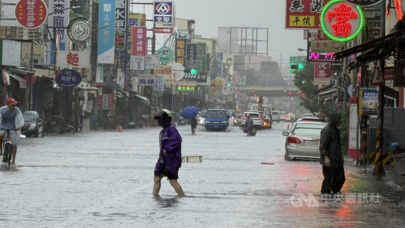 屏東大雨不斷，24日東港鎮中正路2段水淹約50公分高，不少民眾涉水而過。中央社記者李卉婷攝　115年8月24日