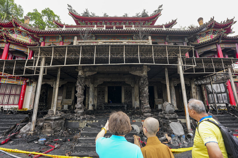 台北市文山區指南宮凌霄寶殿24日晚間發生火警，建物1樓嚴重燒損，火勢撲滅後有民眾25日在封鎖線外察看焦黑的殿體及災損情形。中央社記者鄭清元攝　115年8月25日
