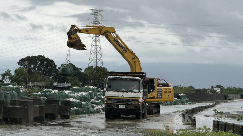 屏東縣萬丹興化廍堤防在6月豪雨時損壞，縣府先堆置臨時應急太空包因應汛期。不過8月連續3天豪大雨導致太空包底部失穩、下陷位移，縣府25日派員回填封堵。中央社記者李卉婷攝　115年8月25日