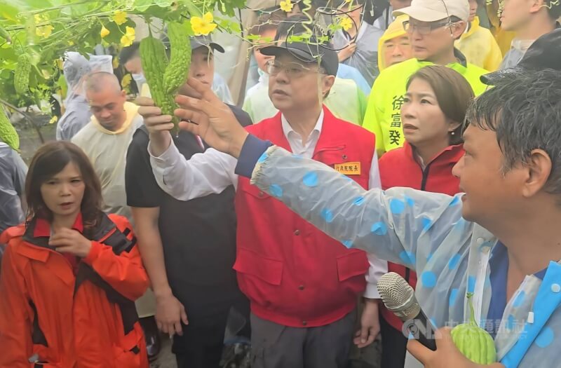 屏東連日大雨，農業災損嚴重，行政院長卓榮泰（前右3）25日前往南州鄉苦瓜園勘災，由南州蔬菜產銷第1班班長李進發（右1）說明災損。中央社記者黃郁菁攝　115年8月25日