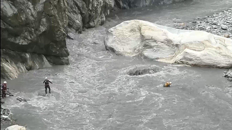 到花蓮慕谷慕魚從事山域活動的2人，因大雨造成溪水暴漲受困河岸岩洞內，花蓮縣消防局26日第3度營救，現場地勢陡峭、溪水仍相當湍急，消防人員渡溪驚險救人。（民眾提供）中央社記者李先鳳傳真　115年8月26日