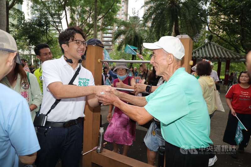 民進黨台北市長參選人沈伯洋（前左）28日上午到象山公園掃街拜票，與運動中的民眾握手致意。中央社記者翁睿坤攝　115年8月28日