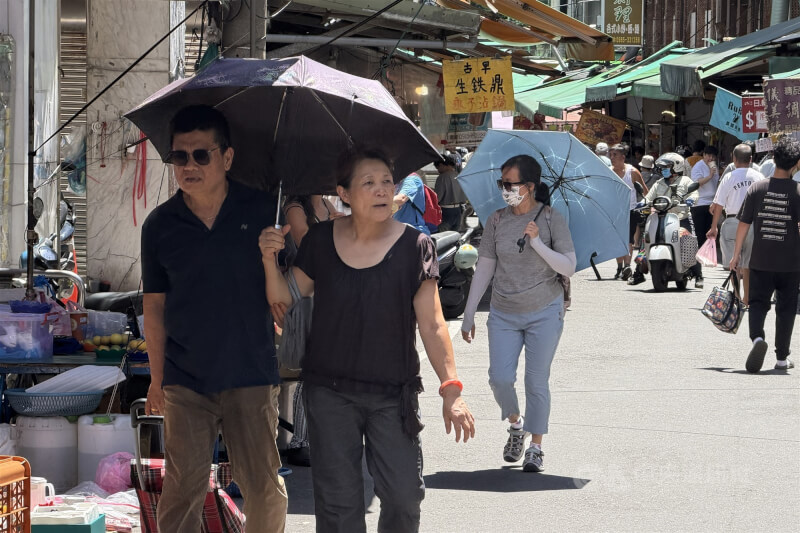 台北市北投區民眾外出撐傘遮陽。（中央社檔案照片）