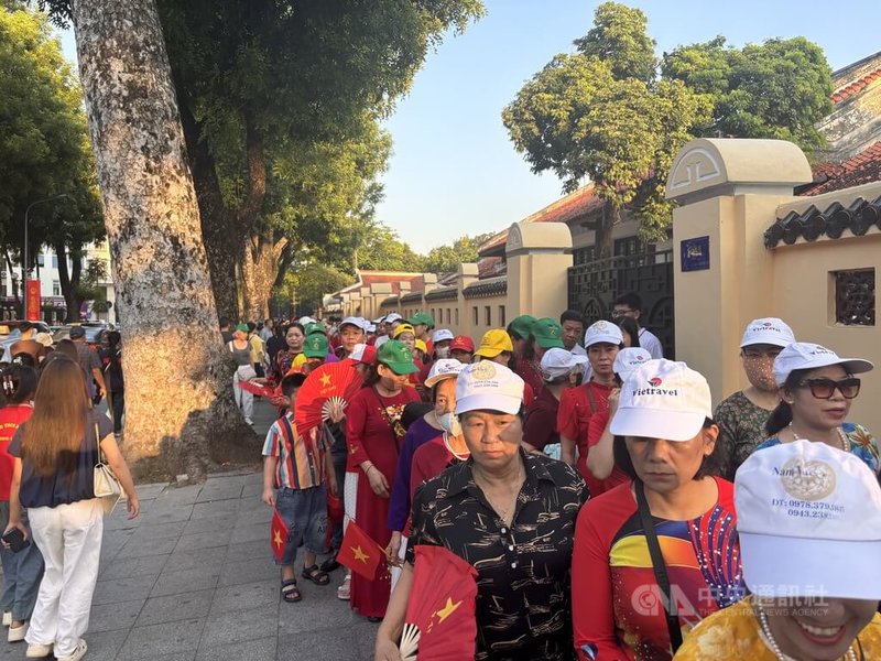 2日升旗典禮後,巴亭廣場後方兩側各出現數百公尺人龍,不少民眾無懼豔陽,要排隊進入廣場管制區內,近距離與廣場和胡志明陵寢紀念館合影留念。中央社記者曾婷瑄河內攝 115年9月2日
