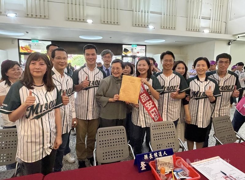 民進黨苗栗縣長參選人陳品安(前右4)2日由競總主委葉菊蘭(前右5)等人陪同下赴選委會正式登記參選,眾人身穿「苗栗隊」棒球衣,象徵團結一心拚勝選。中央社記者管瑞平攝 115年9月2日