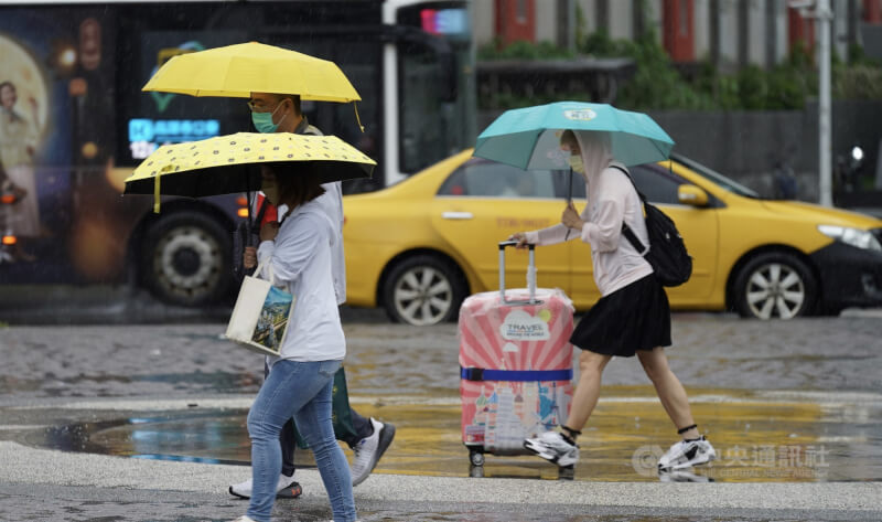 高雄市前鎮區民眾撐傘走在街頭。（中央社檔案照片）