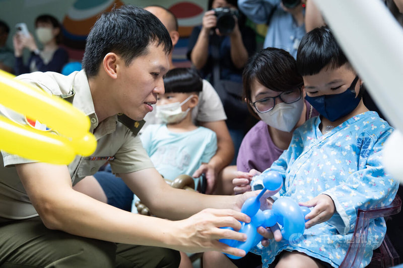 9月3日是軍人節,軍備局205廠高家祥少校(左)前往北榮兒童病房,親自折氣球並與孩童互動。中央社記者游凱翔攝 115年9月3日