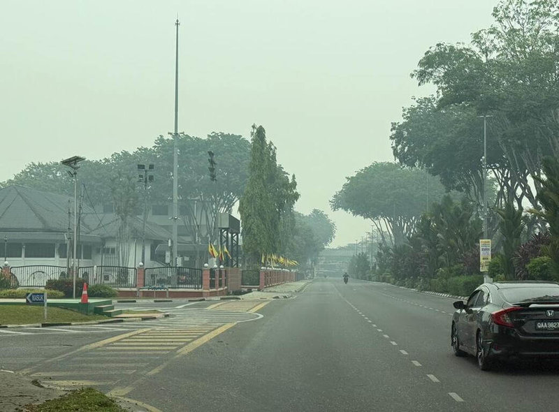 煙霾籠罩馬來西亞砂拉越古晉，市區道路與遠處景物蒙上一層灰白色霧氣，能見度明顯下降。（砂拉越行動黨民都魯支部主席周長佑提供）中央社記者黃自強吉隆坡傳真　115年9月4日