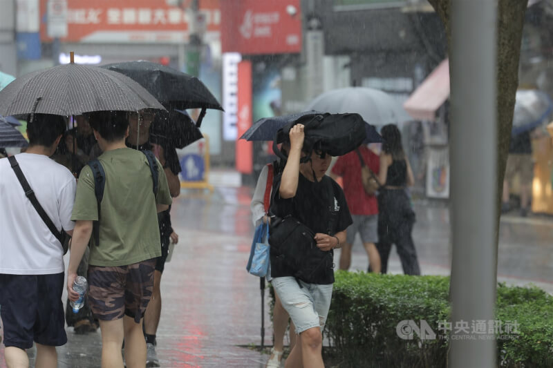 圖為台北市中正區午後一度下起大雨，民眾以包包遮擋雨勢。中央社記者翁睿坤攝　115年9月5日