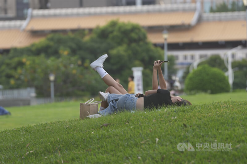 台北圓山花博公園民眾躺在草坪上，享受午後時光。（中央社檔案照片）