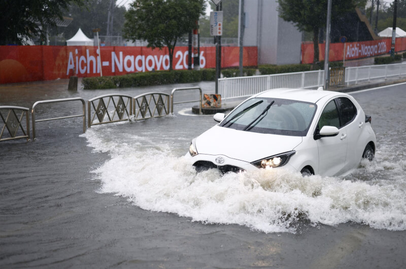 名古屋8日遭遇破紀錄暴雨，一輛汽車行駛在淹水的道路上。 （共同社）