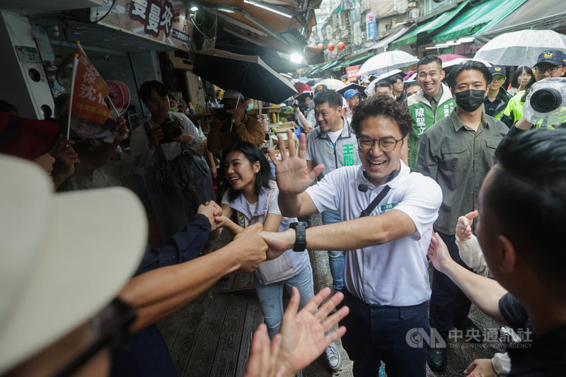民進黨台北市長參選人沈伯洋（前右）11日上午赴大安區臨江市場掃街拜票，不少支持者冒雨前來，為沈伯洋加油打氣。中央社記者裴禛攝　115年9月11日