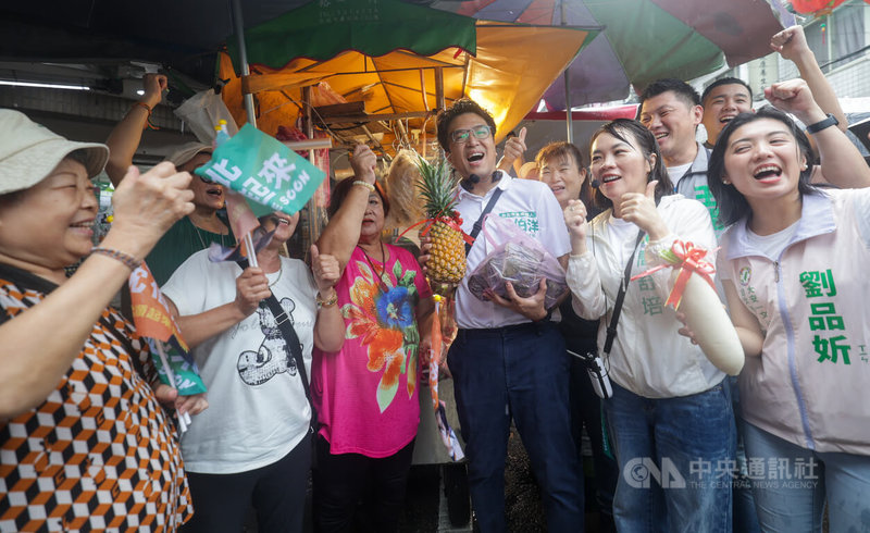 民進黨台北市長參選人沈伯洋（前右3）11日赴大安區臨江市場掃街拜票，攤商送上鳳梨、粽子和蘿蔔，祝福台北隊選戰順利。中央社記者裴禛攝　115年9月11日