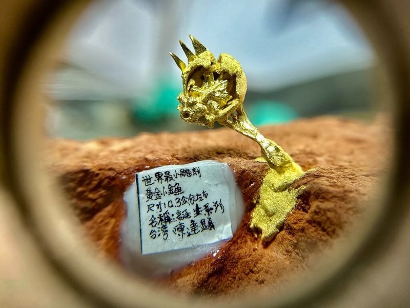 台灣毫芒雕刻家陳逢顯挑戰極限工藝，歷經3個月創作，推出黃金微雕作品「叉子上的金魚」。僅0.3公分的黃金魚，展現雕刻的技藝，作者稱，作品象徵關於生命渴望自由。（陳逢顯提供）中央社記者黃旭昇傳真  115年9月12日
