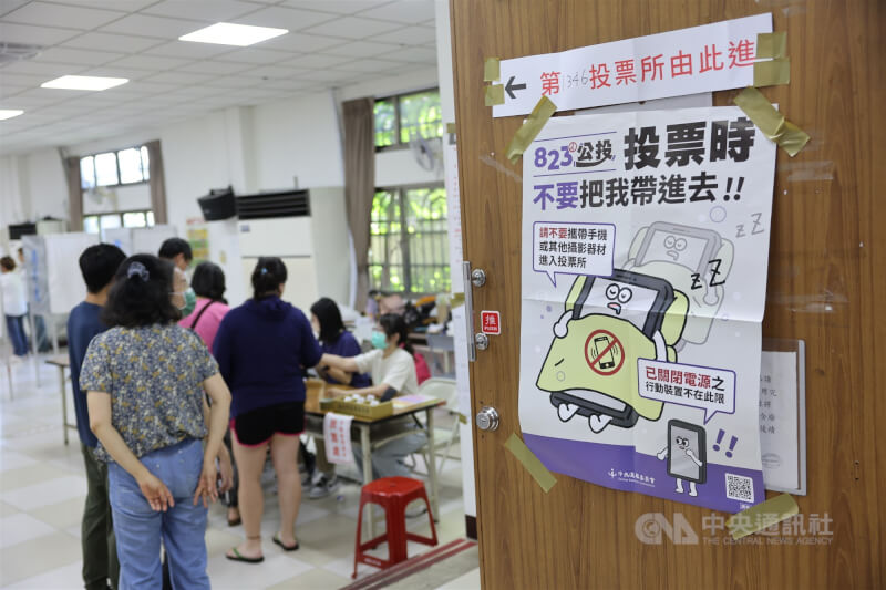 最新「全球民主現況」報告指出，台灣去年在「公民參與」方面名列全球第7。圖為去年8月核三重啟公投案投票日，新北市板橋區港嘴市民中心投票所外張貼注意事項，提醒勿帶手機或其他攝影器材進入。（中央社檔案照片）