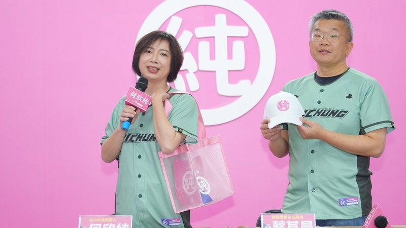 民進黨籍台中市長參選人何欣純（左）16日在位於南屯區的競選總部公布首波募款感恩小物，並與競總主委蔡其昌（右）穿上球衣，共同展示網袋及「純」字帽等。（何欣純辦公室提供）中央社記者蘇木春傳真　115年9月16日
