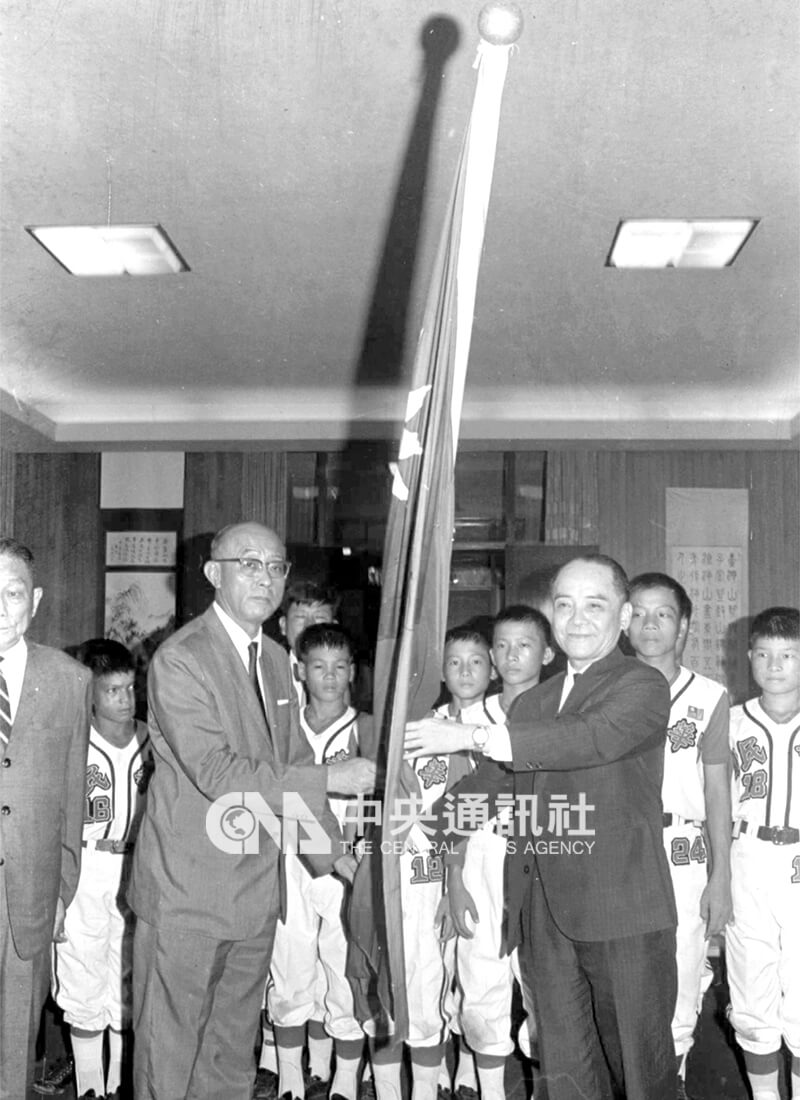 教育部長鍾皎光（右）在教育部會議室內授旗中華少年棒球隊，由領隊謝國城接受。中央社記者馮國鏘攝 58年8月12日