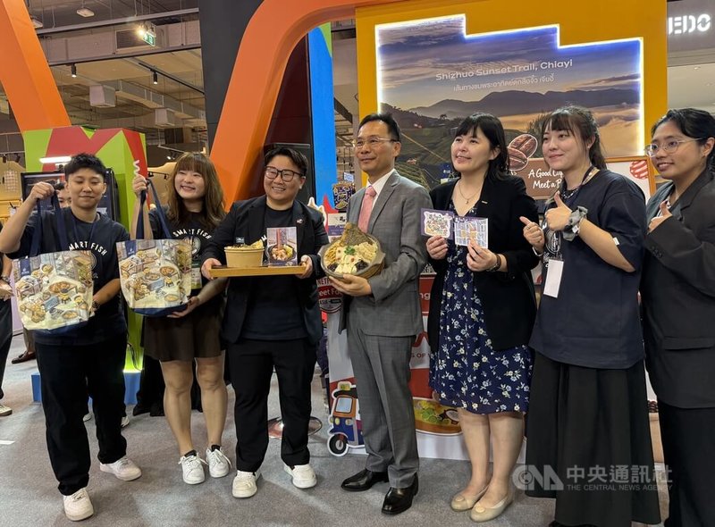 曼谷18日登場的台灣旅展展示嘉義特色美食，並提供沙鍋魚頭供民眾免費享用。圖為與林聰明沙鍋魚頭執行長林佳慧（左3）與駐泰代表藍夏禮（中）和觀光署曼谷辦事處主任陳憶婷（右3）合影。中央社記者李宗憲曼谷攝　115年9月18日