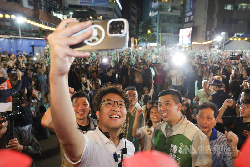 民進黨台北市長參選人沈伯洋（前中）18日晚間走訪景美夜市掃街拜票，拿起手機和現場人潮自拍。中央社記者謝佳璋攝  115年9月18日