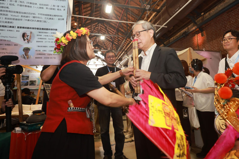 2026全國古蹟日活動19日在台中文化部文化資產園區熱鬧開幕,文化部長李遠(前右)出席並參觀屏東縣政府攤位,現場體驗吹奏鼻笛。(文化部提供)中央社記者邱祖胤傳真 115年9月19日