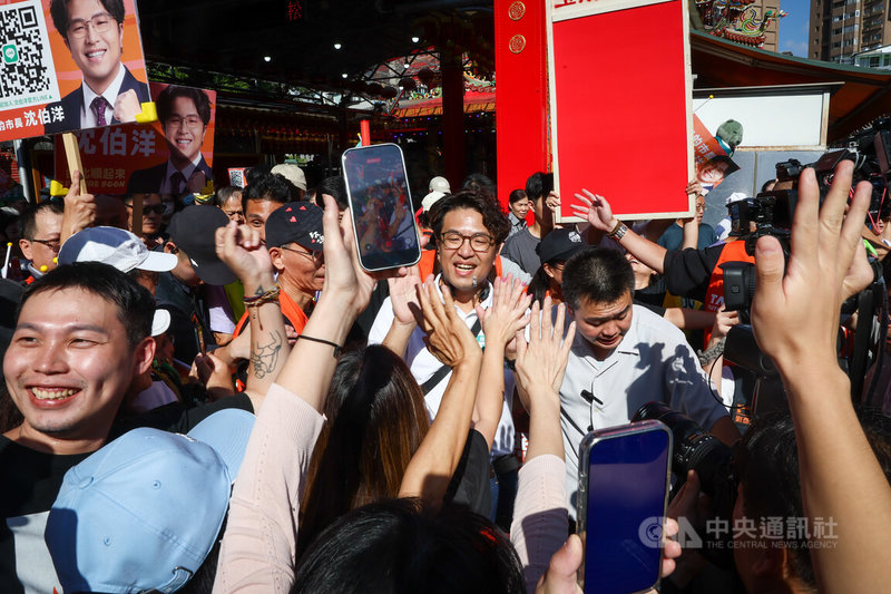 民進黨台北市長參選人沈伯洋（中）23日下午現身台北五分埔商圈掃街拜票，吸引大批支持者到場迎接，爭相擊掌合影。中央社記者王騰毅攝  115年9月23日