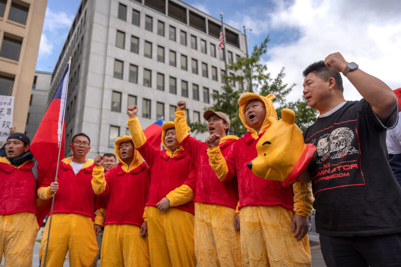 中國國家主席習近平訪問美國期間，抗議人士24日穿著小熊維尼裝在白宮附近示威。（美聯社）