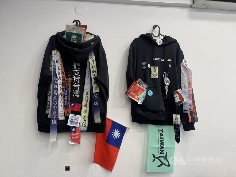 捷克布拉格的手搖飲店Lootea，牆面上的帽T累積許多台灣旅客贈送的紀念品，包含中華民國國旗，還有「我那小小多山的國家」與「望你順遂 台灣」字樣的絲帶，以及珍珠奶茶吊飾、台灣黑熊磁鐵等，琳瑯滿目。中央社記者劉郁葶布拉格攝　115年9月26日