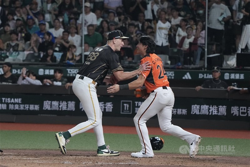 中華職棒統一7-ELEVEn獅隊27日在台北大巨蛋交手台鋼雄鷹隊，9局上，獅隊跑者陳傑憲（右）趁傳進壘，成功回到本壘得分，與雄鷹投手坎南（左）面面相覷。中央社記者徐肇昌攝　115年9月27日