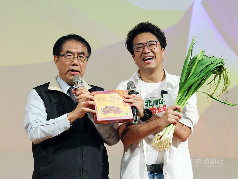 民進黨台北市長參選人沈伯洋(右)28日出席台南之友後援會成立大會,黨籍台南市長黃偉哲(左)到場站台,送上象徵「當蒜」的當歸、大蒜,預祝勝選。中央社記者郭日曉攝 115年9月28日