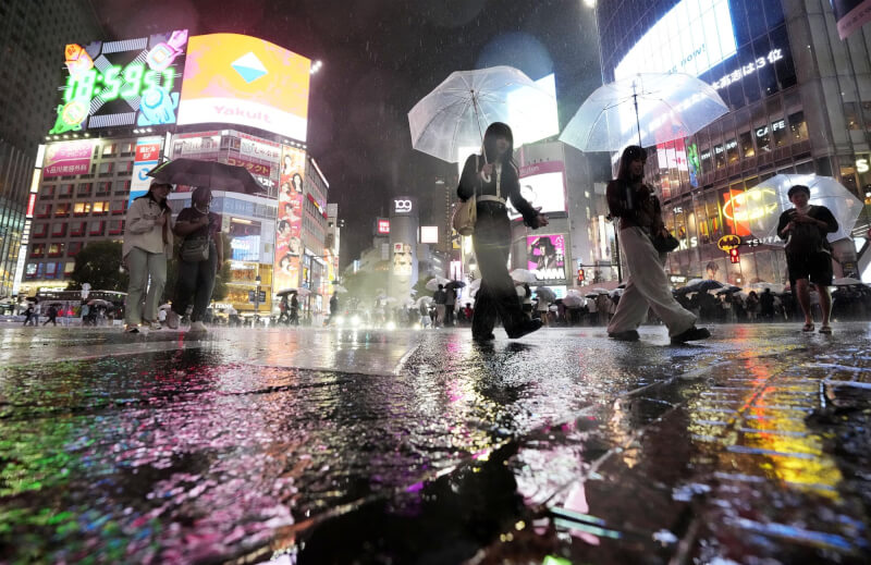 東京澀谷20日下雨，民眾撐傘過馬路。（共同社）