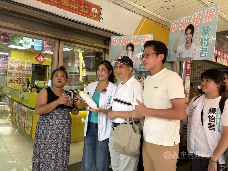 民眾黨主席黃國昌（右2）30日上午與黨籍新北市議員參選人陳怡君（左2）前往中和區華新街市場掃街，民眾致贈象徵好彩頭的白蘿蔔，祝福當選。中央社記者曹亞沿攝　115年9月30日