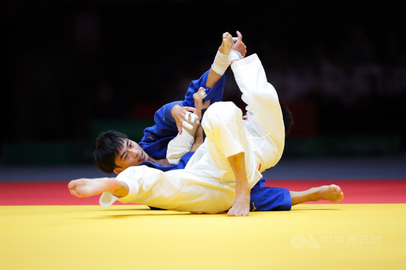 名古屋亞運30日柔道男子60公斤級銅牌戰，台灣柔道一哥楊勇緯（藍衣）多次使用招牌地板動作，與中國對手僵持近20分鐘，仍不敵對手落敗。中央社記者翁睿坤愛知攝　115年9月30日