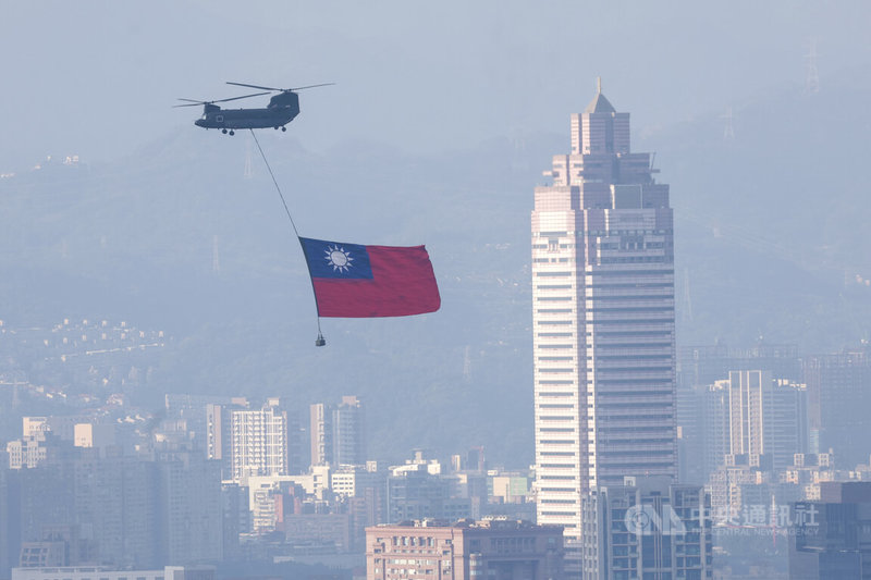 雙十國慶將至，國軍2日上午展開空中全兵力預演，陸軍CH-47SD契努克運輸直升機吊掛巨幅國旗，飛往總統府方向。中央社記者裴禛攝　115年10月2日