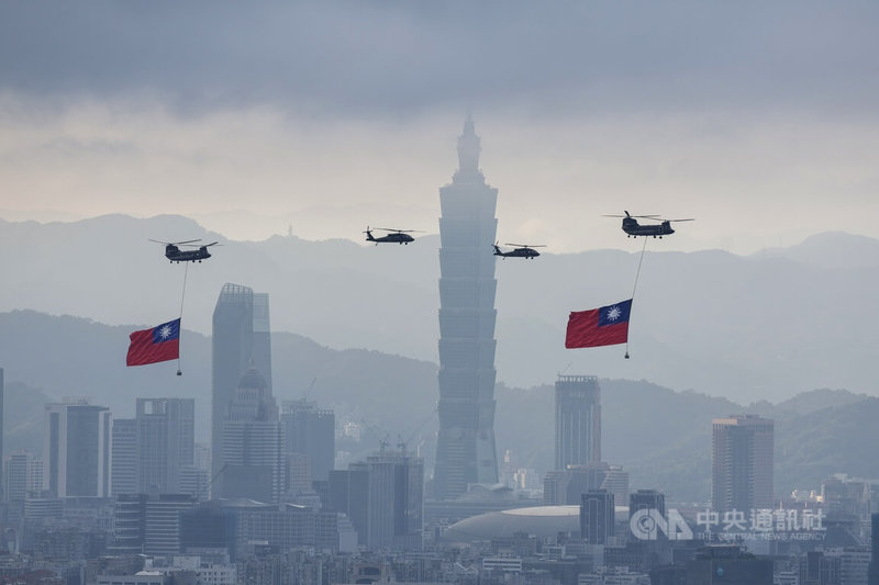 雙十國慶將至，國軍2日上午展開空中全兵力預演，陸軍CH-47SD契努克運輸直升機吊掛巨幅國旗，與UH-60M黑鷹直升機組成國旗機隊，飛往總統府方向。中央社記者裴禛攝　115年10月2日