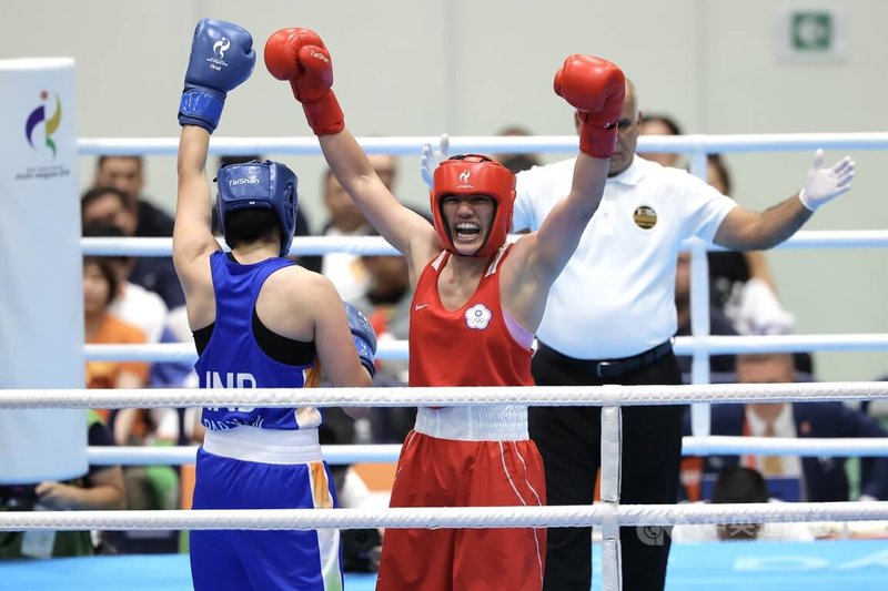 名古屋亞運2日進行女子拳擊65公斤級金牌戰，台灣好手陳念琴（紅衣）面對印度選手，雙方激烈交戰3回合，比賽結束那刻，陳念琴高舉雙手展現氣勢。中央社記者翁睿坤愛知攝　115年10月2日