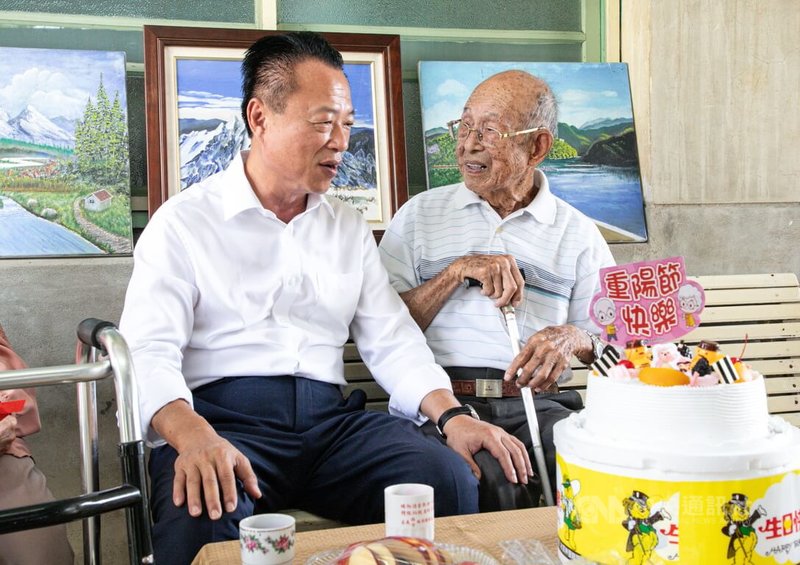 嘉義縣長翁章梁（左）5日探訪水上鄉百歲人瑞王柏雄（右）；王柏雄耳聰目明像6旬老人，精通日文，百歲還在投資股市。中央社記者蔡智明攝　115年10月5日