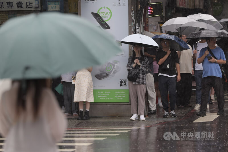 台北市中正區降雨，街頭民眾紛紛撐起傘來。（中央社檔案照片）