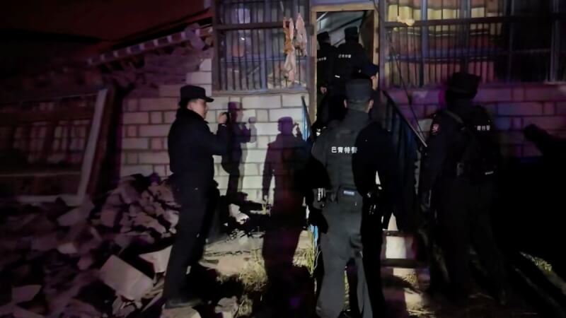 中國西藏那曲市巴青縣22日晚發生規模7地震，警方從受損的房屋內救出受困人員。（Nagqu Police Department/Handout via 路透社）