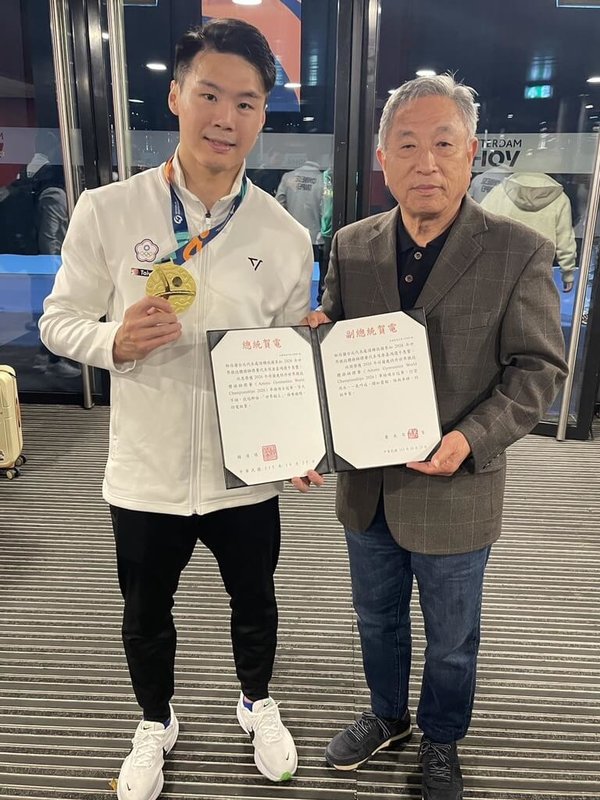 男子單槓選手唐嘉鴻（左）在第54屆世界體操錦標賽奪金，駐荷蘭代表田中光（右）代轉總統賴清德及副總統蕭美琴賀電。（駐荷蘭代表處提供）中央社記者吳柏緯布魯塞爾傳真　115年10月26日